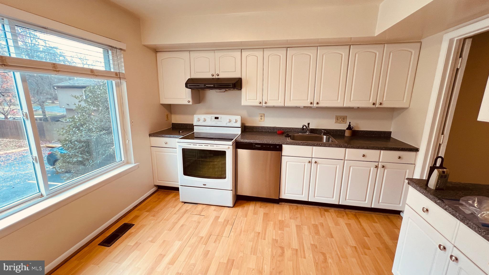 7853 Muirfield Court Potomac, MD 20854 - Photo 3 of 25 a kitchen with a sink a stove and white cabinets