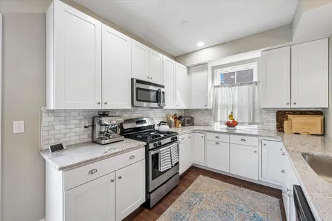 a kitchen with sink a microwave and cabinets