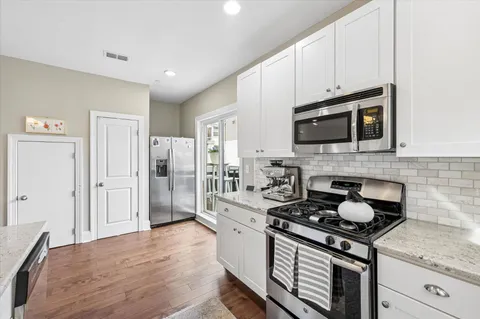 a kitchen with stainless steel appliances kitchen island granite countertop a stove a sink and a microwave