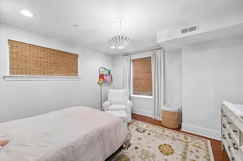 a bedroom with a bed and a window with wooden floor