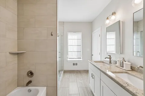 a bathroom with a granite countertop sink a large mirror and shower
