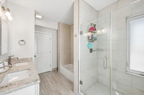 a bathroom with a granite countertop shower a sink and a mirror