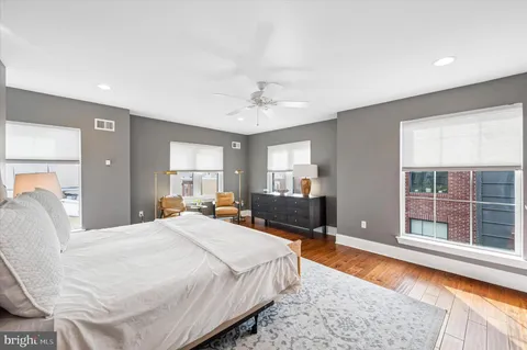 a bedroom with a bed and a large window with balcony view