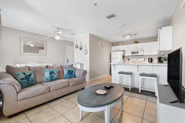 a living room with furniture and a dining table with kitchen view
