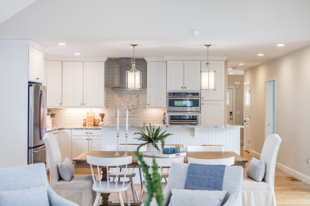 56 Cottage Lane Mashpee, MA 02649 - Photo 12 of 42 a kitchen with stainless steel appliances granite countertop a refrigerator a sink a stove a dining table and chairs