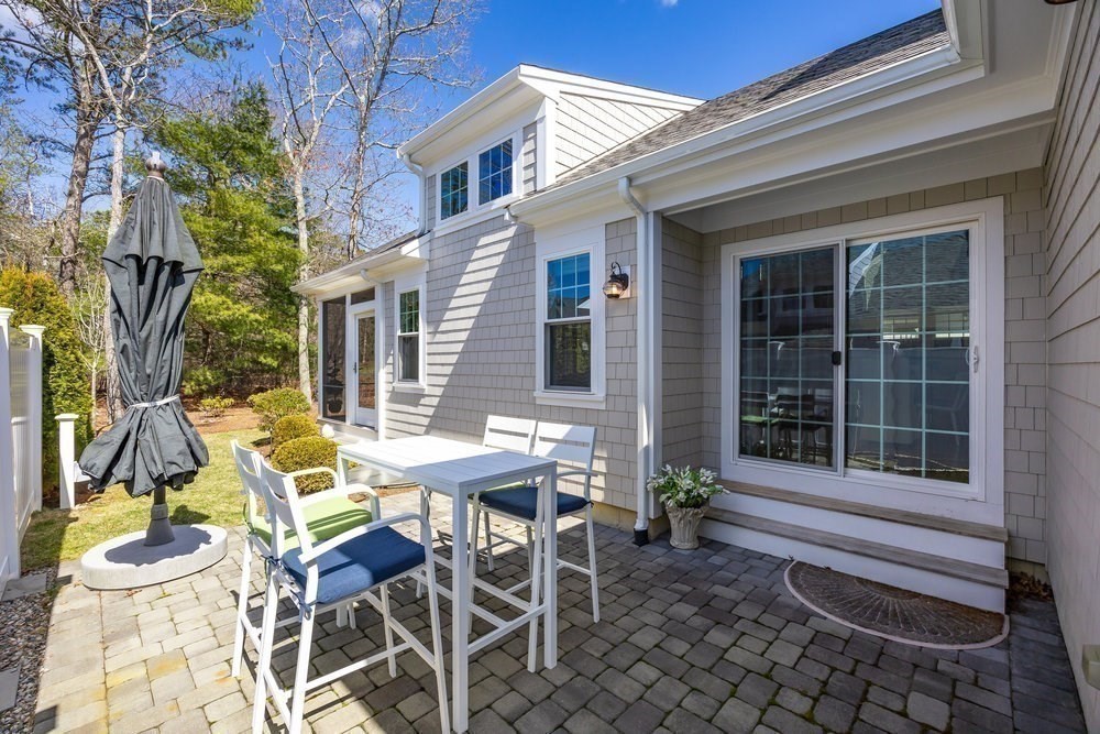 56 Cottage Lane Mashpee, MA 02649 - Photo 33 of 42 a view of a patio with table and chairs and potted plants