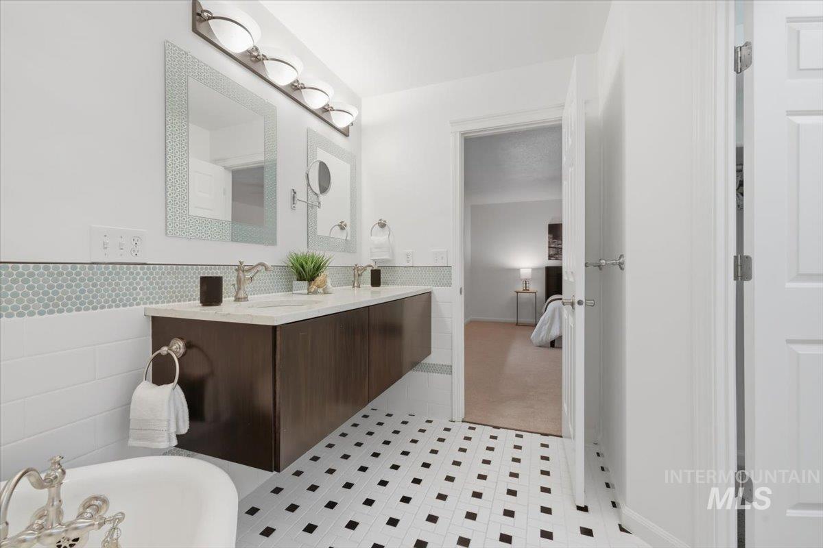 2075 North Springland Place Boise, ID 83713 - Photo 25 of 49 Bathroom featuring a dual-sink floating vanity with a light-colored countertop, individual framed mirrors, and a four-light fixture