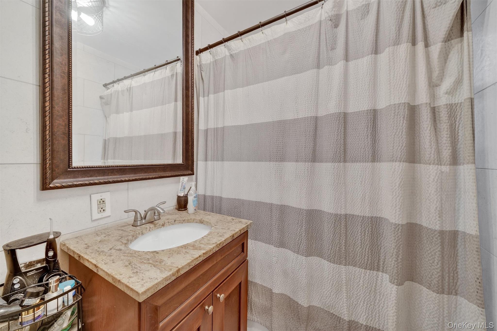 475 Bronx River Road, Unit 2D Yonkers, NY 10704 - Photo 25 of 27 a bathroom with a granite countertop sink and a mirror