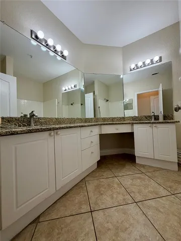 a large white kitchen with a sink and cabinets