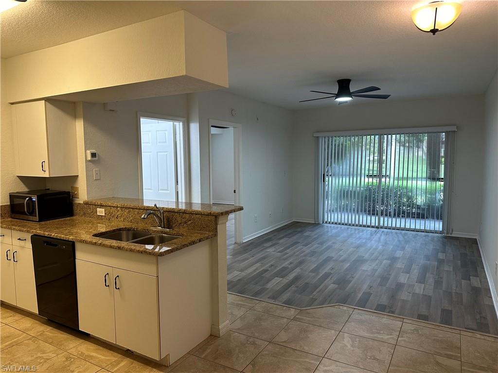 Kitchen with dishwasher, stone counters, white cabinetry, sink, and ceiling fan