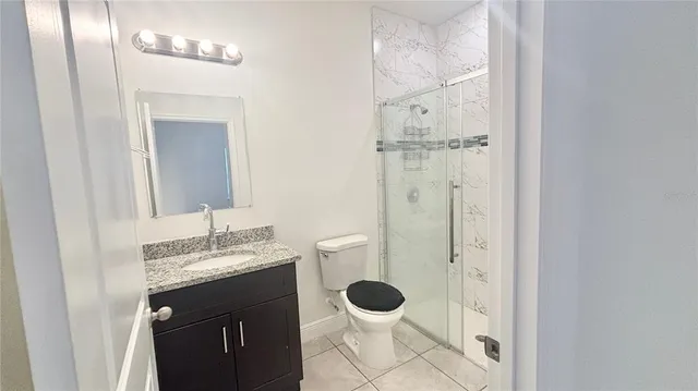 a bathroom with a granite countertop sink a toilet and a mirror