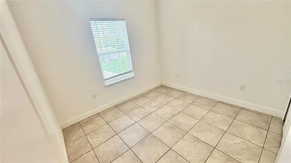 an empty room with white walls and tiles
