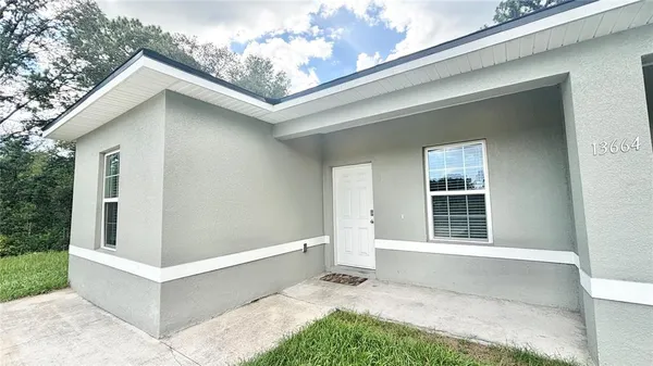 a view of house with backyard and glass windows