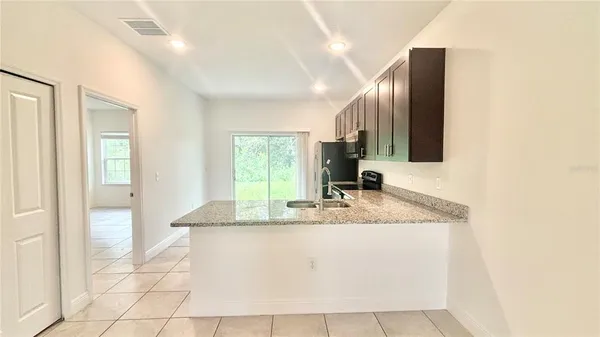 a bathroom with a granite countertop sink a mirror and a faucet