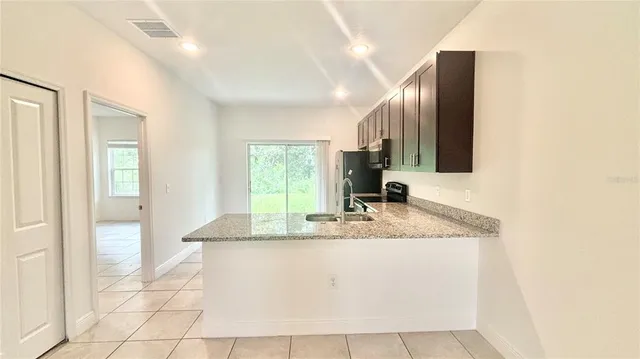 a bathroom with a granite countertop sink a mirror and a faucet