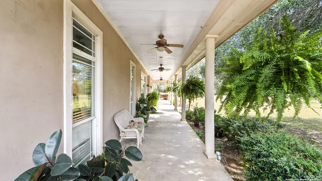 a porch with seating space and trees in the background