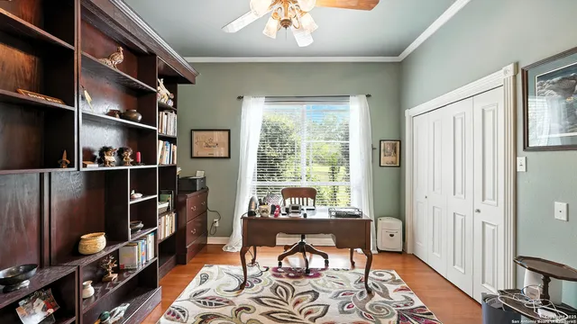 a view of a dining room with furniture a chandelier and large windows