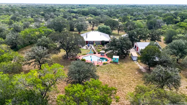 an aerial view of a house with yard and outdoor seating