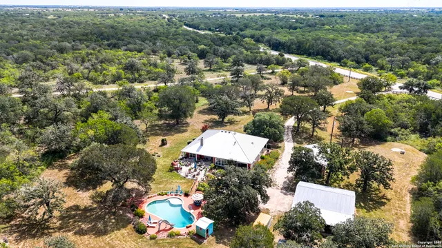 a view of a green field with trees in the background