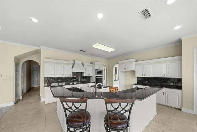 a view of a kitchen with kitchen island granite countertop a sink and a large window