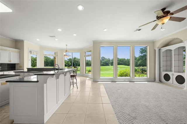 a view of a livingroom with a furniture window a ceiling fan and front door