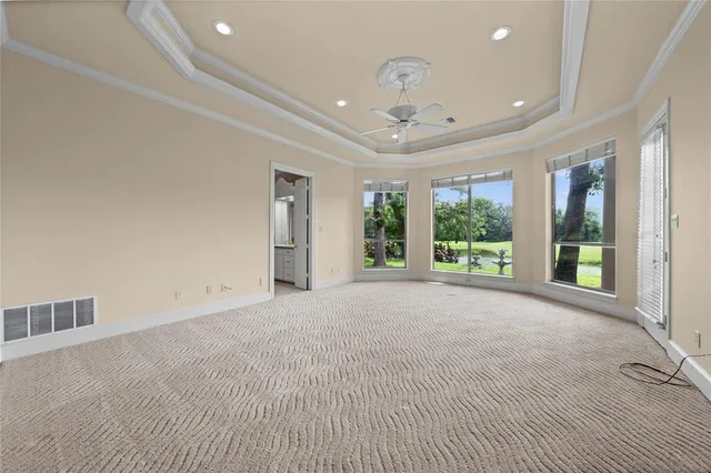 a view of an empty room with windows and a chandelier