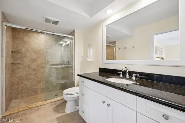 a en suite bathroom with a granite countertop sink and a mirror