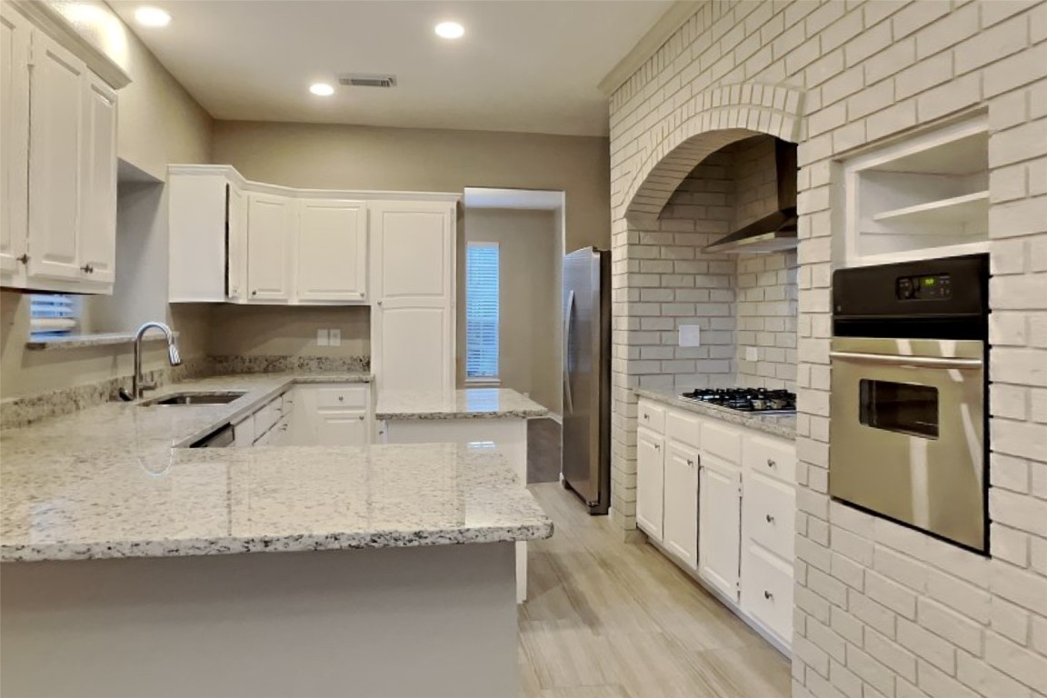 16411 Willingham Way Houston, TX 77095 - Photo 4 of 21 a kitchen with granite countertop a sink stainless steel appliances and white cabinets