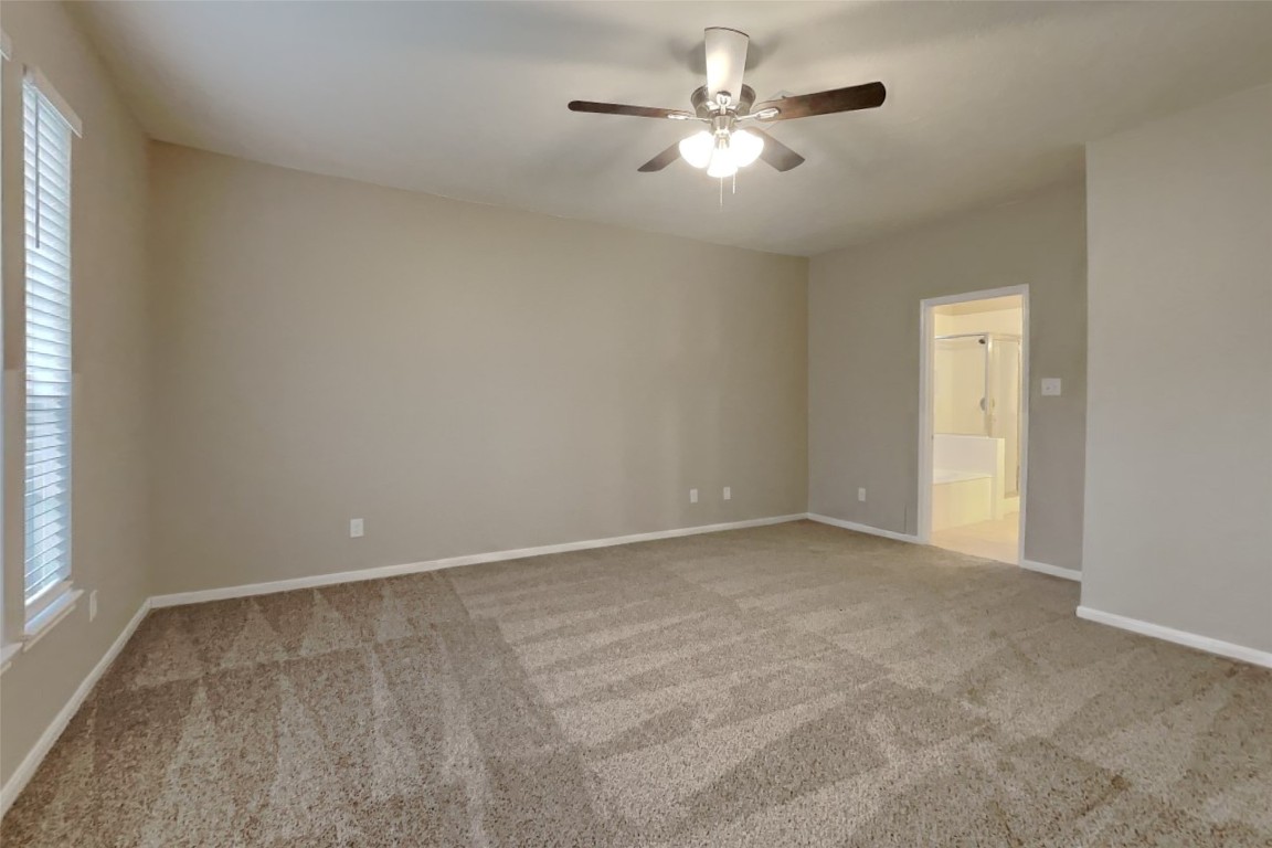 16411 Willingham Way Houston, TX 77095 - Photo 9 of 21 an empty room with a chandelier fan and windows