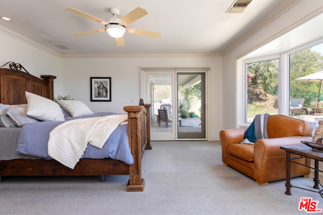 10935 Alta View Drive Studio City, CA 91604 - Photo 19 of 45 a spacious bedroom with a bed couch and a large window