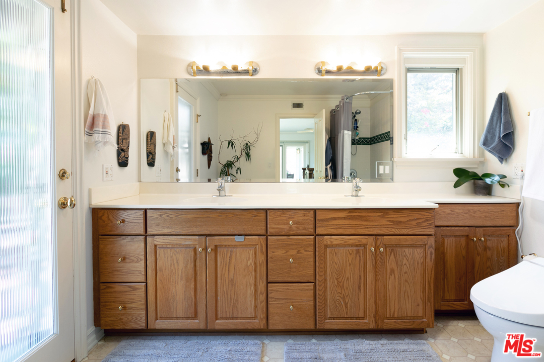 10935 Alta View Drive Studio City, CA 91604 - Photo 22 of 45 a bathroom with a double vanity sink a mirror and a toilet