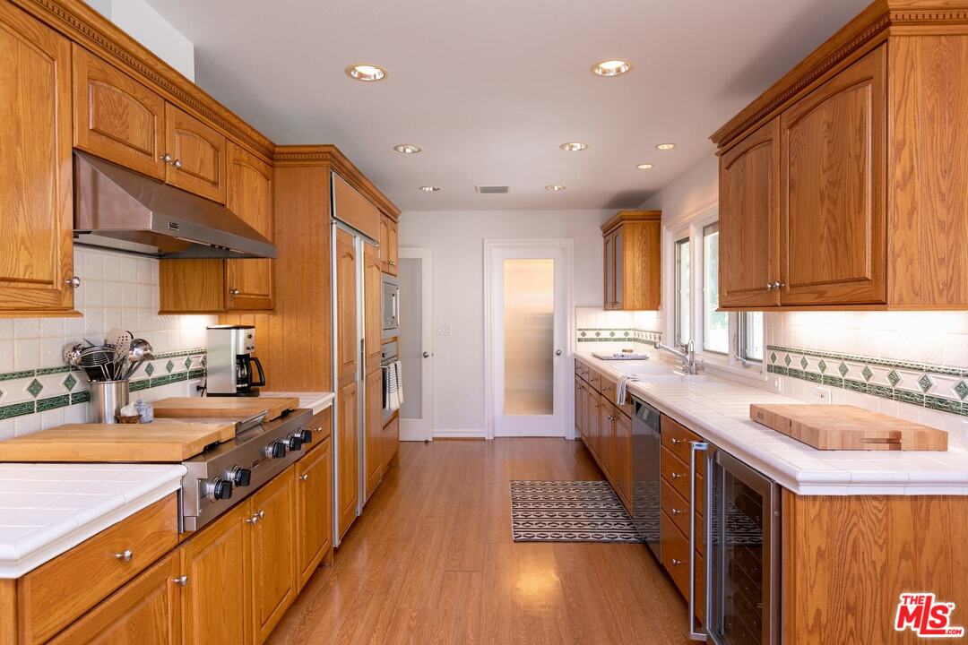10935 Alta View Drive Studio City, CA 91604 - Photo 10 of 45 a large kitchen with stainless steel appliances granite countertop a lot of counter space and wooden floor