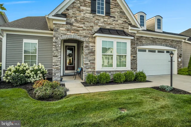 a front view of a house with a garden and plants