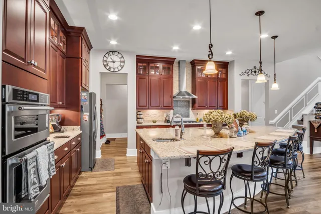 a kitchen with stainless steel appliances a dining table chairs stove and cabinets