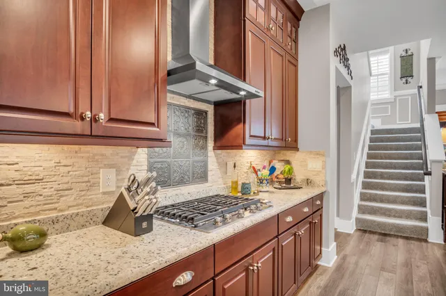 a kitchen with stainless steel appliances granite countertop a sink stove and cabinets