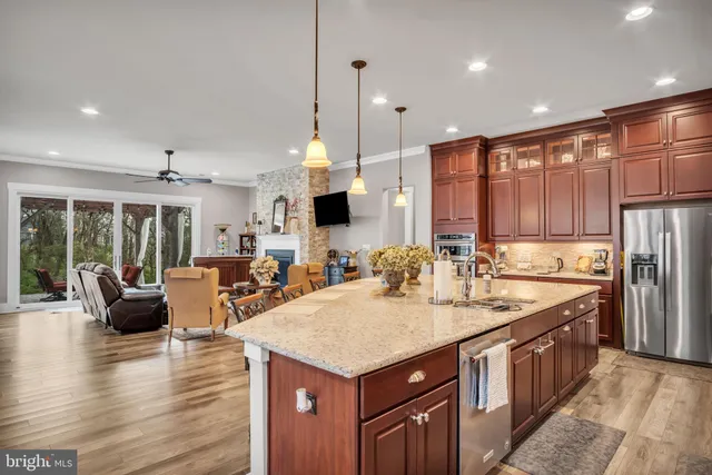 a kitchen with stainless steel appliances granite countertop a refrigerator and a wooden cabinets