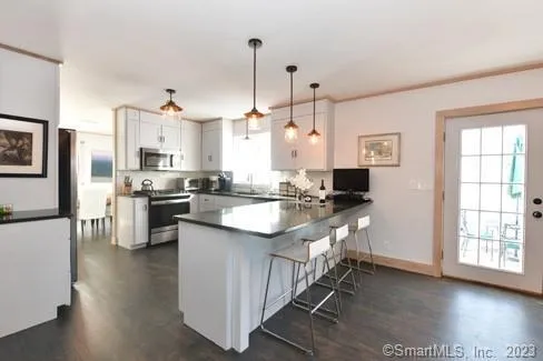 a kitchen with stainless steel appliances kitchen island granite countertop a sink a stove and a refrigerator
