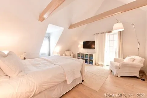 a spacious bedroom with a bed and a flat screen tv