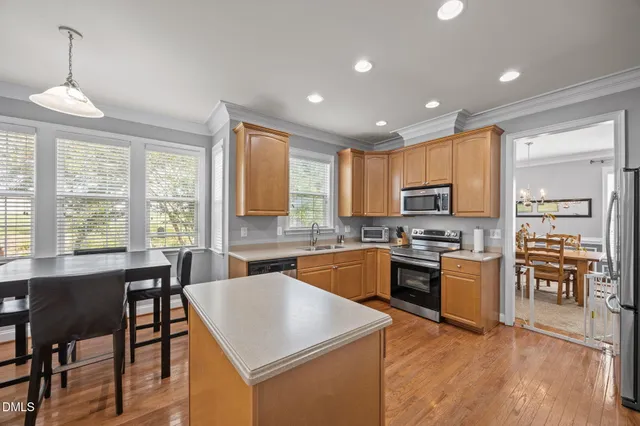 a large kitchen with kitchen island a sink stainless steel appliances and cabinets