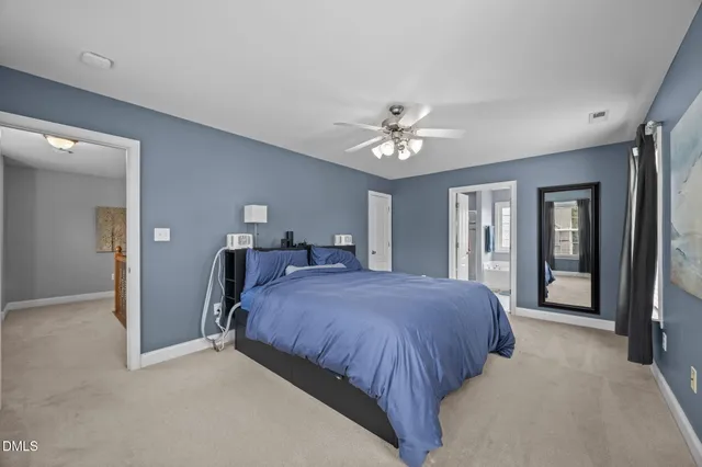 a spacious bedroom with a bed and a chandelier