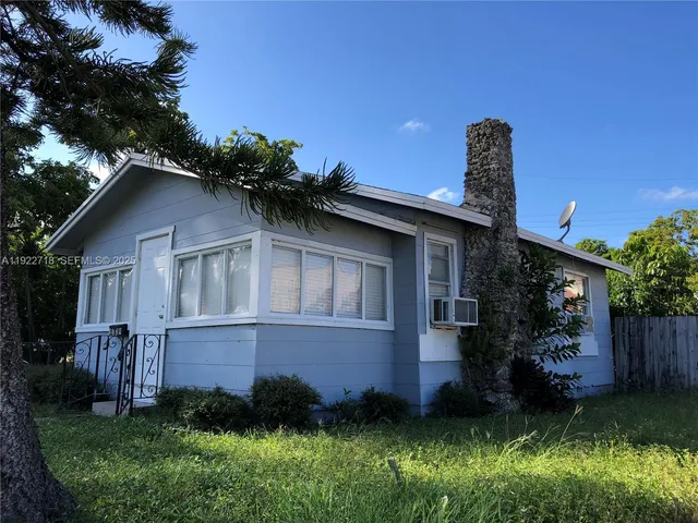 a front view of a house with a yard and potted plants