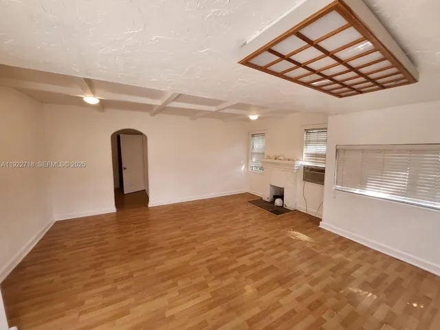 a view of empty room with a fireplace and wooden floor