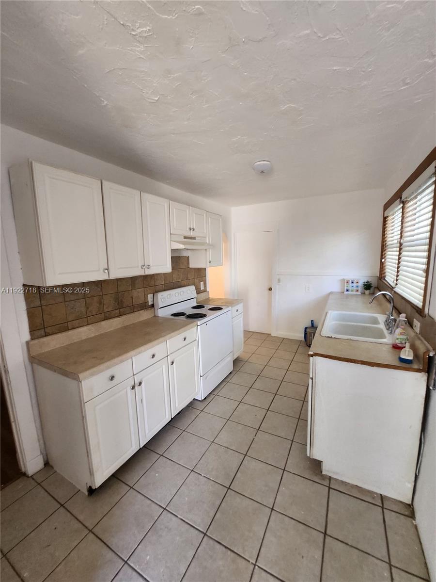 2129 Taylor Street Hollywood, FL 33020 - Photo 8 of 9 a kitchen with a stove top oven sink and cabinets
