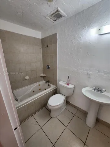 a bathroom with a toilet sink a mirror and bathtub