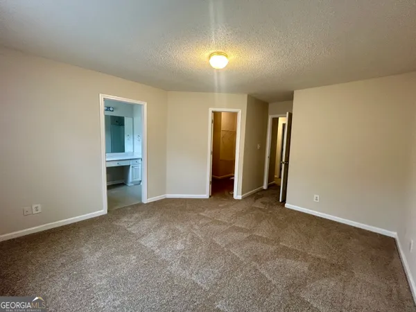 an empty room with closet and windows