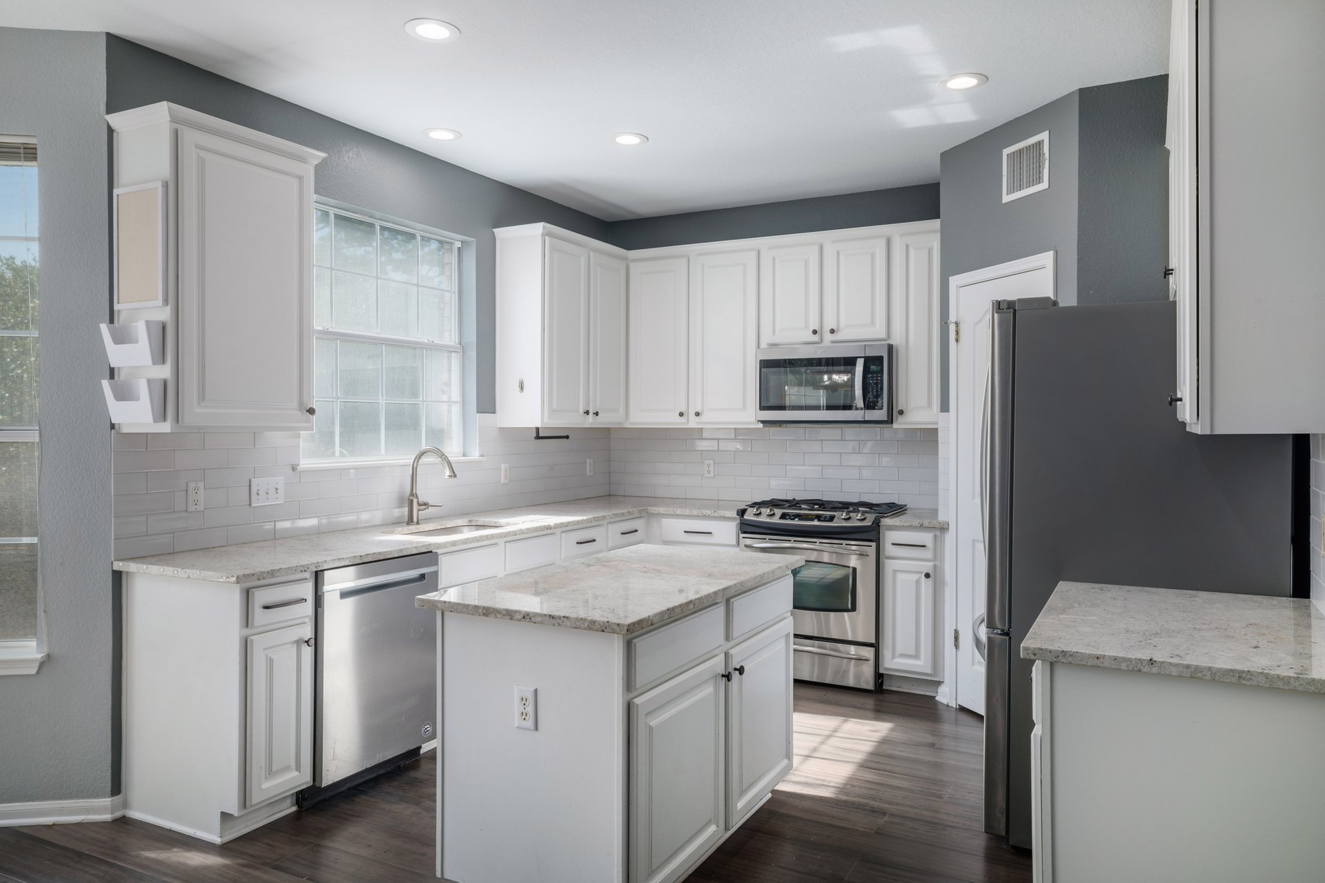 7113 Bending Oak Road Austin, TX 78749 - Photo 4 of 39 Crisp cabinetry and granite countertops frame a central island in this well-appointed kitchen with walk-in pantry.