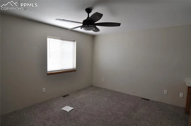 a view of a livingroom with a chandelier fan and a kitchen