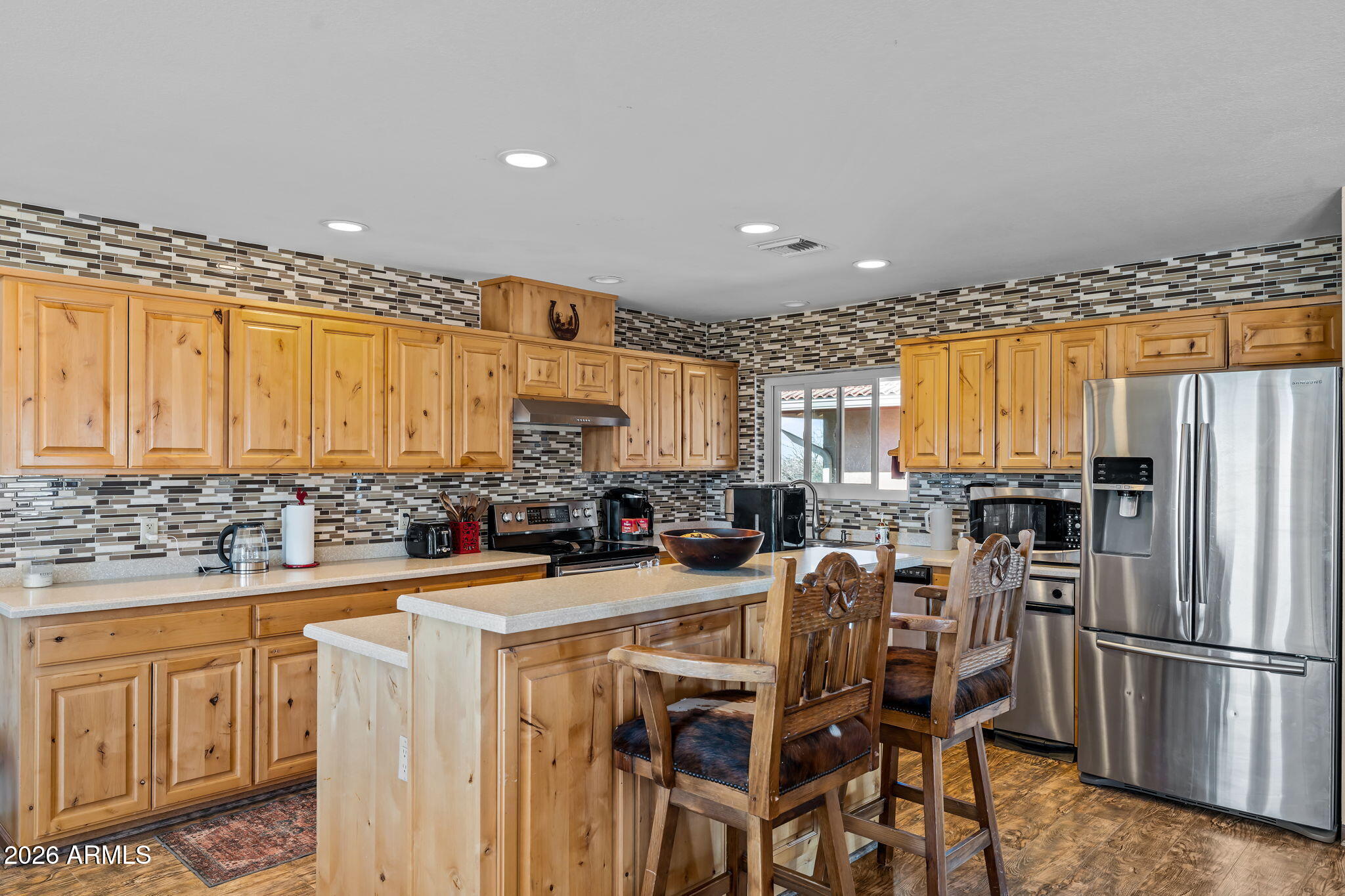 35085 South Turtle Creek Road Wickenburg, AZ 85390 - Photo 17 of 55 a kitchen with stainless steel appliances granite countertop a refrigerator a stove a sink dishwasher with a dining table and chairs
