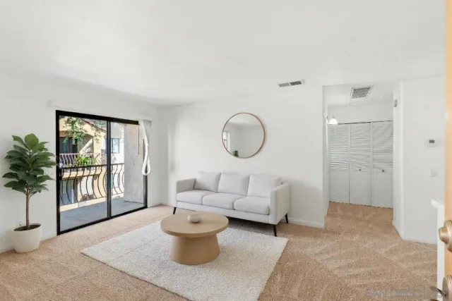 a living room with furniture a window and a potted plant