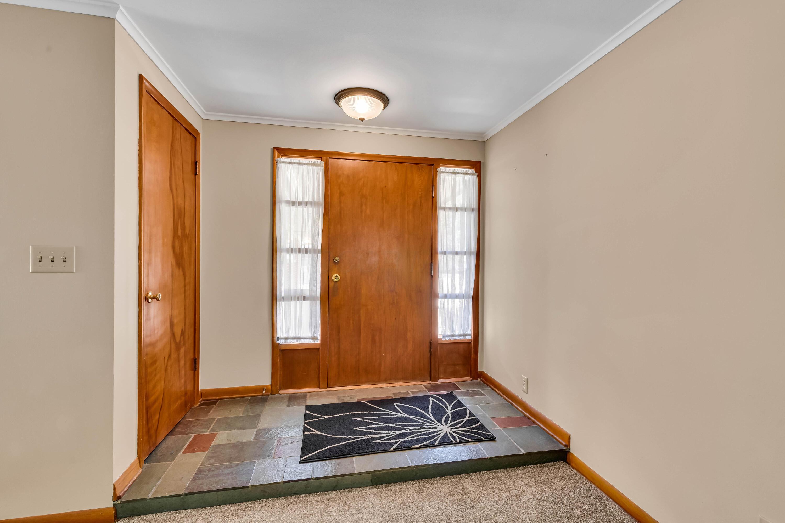 1213 East Cooke Road Columbus, OH 43224 - Photo 8 of 57 • Slate tile flooring • Tan painted walls • Ceiling light • Lighted closet • Sidelights by front door • Step-down to Great Room